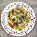 Śledzie pokrojone w małe kawałki, następnie polane olejem i podawane z kaparami, cebulą i papryczkami chilli na ostro.
