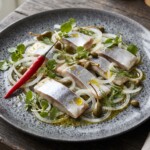Śledzie pokrojone w małe kawałki, następnie polane olejem i podawane z kaparami, cebulą i papryczkami chilli na ostro.