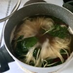 w garnku gotuje się makaron spaghetti razem z botwinką