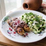 surówka gruzińska z ogórka podana na talerzu z kebabami z grilla po gruzińsku