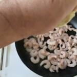 na patelni smażą się obrane krewetki koktajlowe