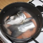 w garnku górują się kawałki łososia