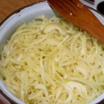 w dużym garnku smaży się dużo cebuli pokrojonej w piórka