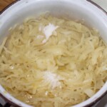 w dużym garnku smaży się duża ilośc cebuli na zupę cebulową