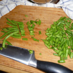 zielona fasolka szparagowa krojona na kawałki na desce kuchennej