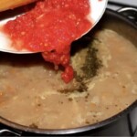 dodawanie startych pomidorów do zupy ze świeżej fasoli w garnku