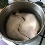 w garnku gotują się dwa udka z kurczaka