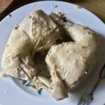 ugotowane dwa udka z kurczaka leżą na talerzu