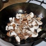 na patelni smażą się pokrojone pieczarki
