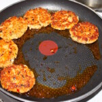 Kotleciki z łososia z pastą curry po tajsku smażą się na patelni