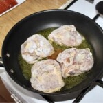 na patelni smażą się cztery udka z kurczaka