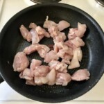 na patelni smażą się małe kawałki piersi z kurczaka
