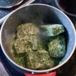 szpinak mrożony w kostkach gotuje się w garnku