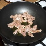 w woku smaży się kurczak pokrojony w mała kostkę