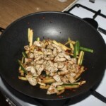 w woku smaży się kurczaka pokrojony w mała kostkę