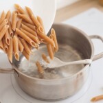 makaron penne razowy wrzucany jest do gotującej się w garnku osolonej wody