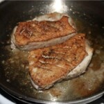 na patelni smażą się dwa piersi z kaczki
