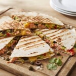 quesadilla z łososiem i awokado pokrojona w trójkąty i podana na talerzu