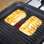 na patelni grillowej smażą się dwa plastry sera halloumi