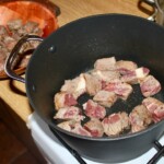 w głębokim garnku smażą się kawałki wołowiny