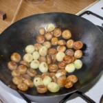 w woku smażą się cebulki perłowe