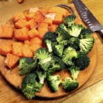 różyczki brokuła i kawałki surowego łososia na desce kuchennej