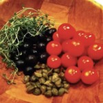 pomidorki koktajlowe i oliwki czarne w drewnianej misce