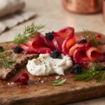 gravlax z burakiem i chrzanem pokrojony w plastry podany na desce z dodatkami