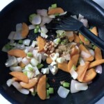 na patelni smażą się pokrojone w kostkę warzywa