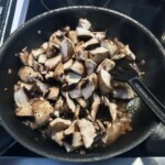 na patelni smażą się pokrojone pieczarki