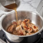 mięso wieprzowe pokrojone w kostkę na gulasz gotuje się w garnku z bulionem