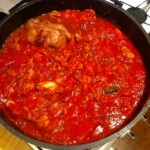 na dużej głębokiej patelni dusi się Gulasz włoski w pomidorach