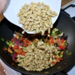 w woku smażą się warzywa i biała fasolka