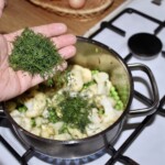 w garnku gotują się różyczki kalafiora z koperkiem siekanym