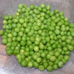 ugotowany i odcedzony na sicie groszek zielony