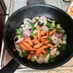 na patelni smażą się pokrojone drobno warzywa