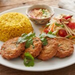Kotleciki rybne przyrządzone z dorsza mielonego z dodatkiem pasty curry, sosu rybnego, sosu sojowego i limonki smażone bezpośrednio przed podaniem.
