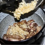 Kotlety cielęce z kostką duszą się z cebulką w garnku