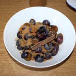 wypestkowane śliwki w misce doprawione cukrem i cynamonem