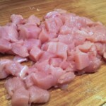pierś z kurczaka pokrojona w małą kostkę na desce kuchennej