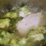 w garnku gotuje się pierś z kurczaka razem z brokułem