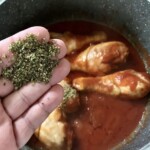 podudzia z kurczaka gotują się w garnku z sosem pomidorowym