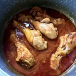 podudzia z kurczaka gotują się w garnku z sosem pomidorowym