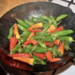 w woku smażą się kolorowe papryczki