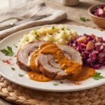 pieczeń wieprzowa w sosie paprykowym podana na talerzu