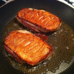 dwie piersi z kaczki smażą się na patelni