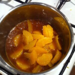 w garnku gotuje się sos pomarańczowy z cząstkami pomarańczy
