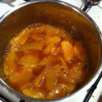 w garnku gotuje się sos pomarańczowy z cząstkami pomarańczy