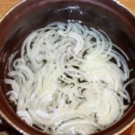 w garnku parzy się w gorącej wodzie cebula krojona w piórka