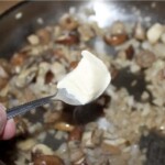 na patelni smażą się pokrojone pieczarki i drobno siekana cebula